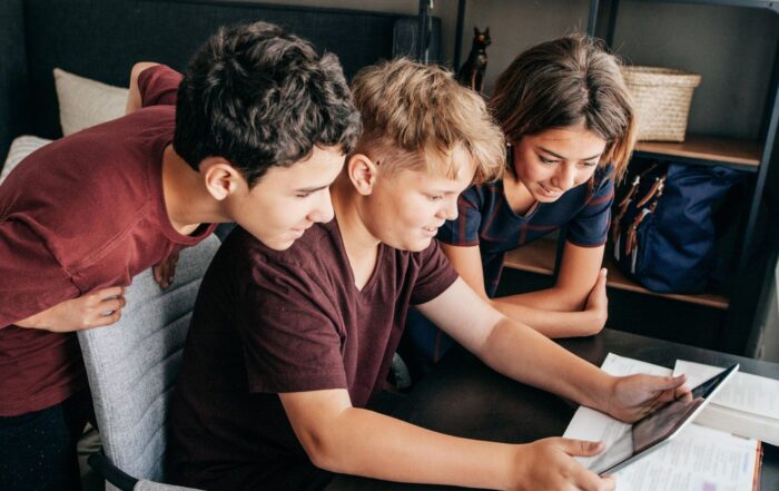 Three young people looking at a tablet together